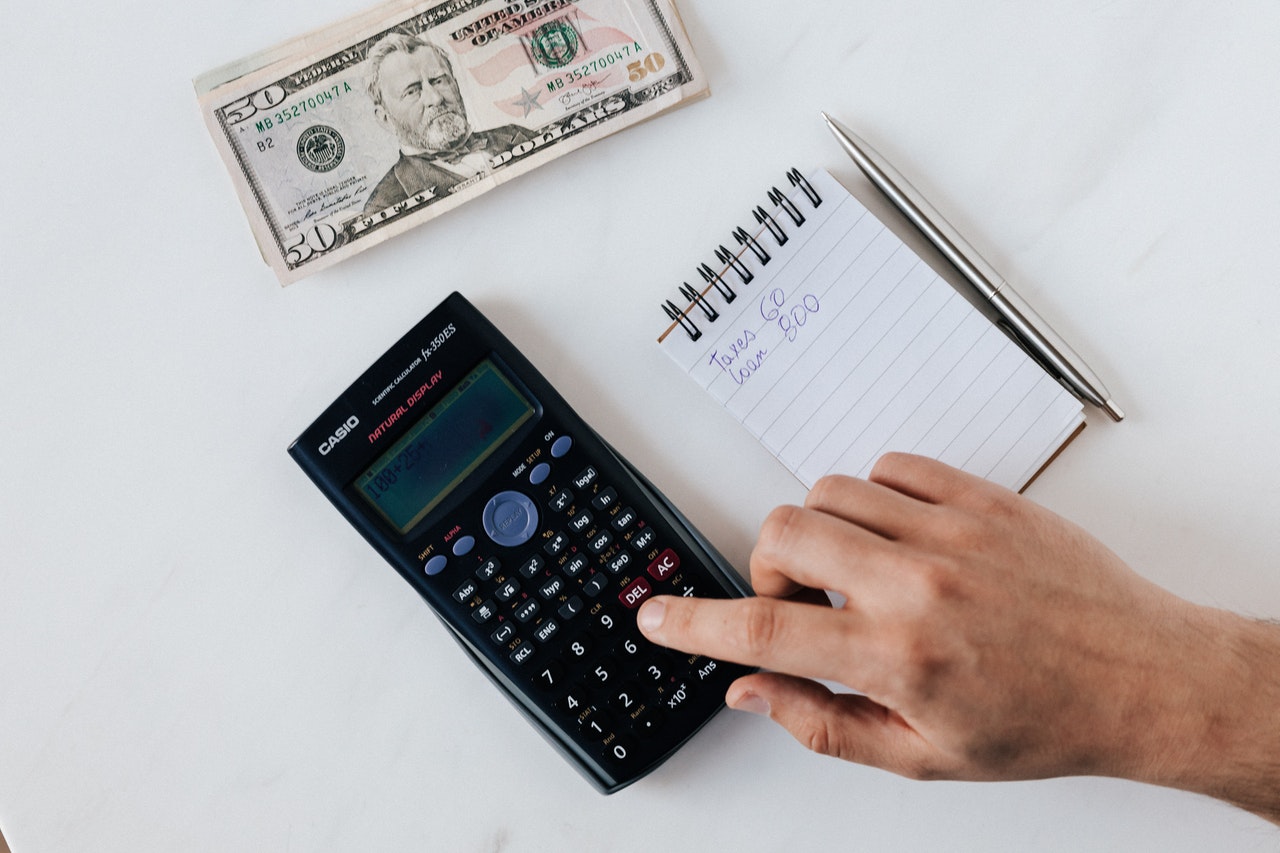 Calcul du salaire brut en net avec une calculatrice et des documents financiers