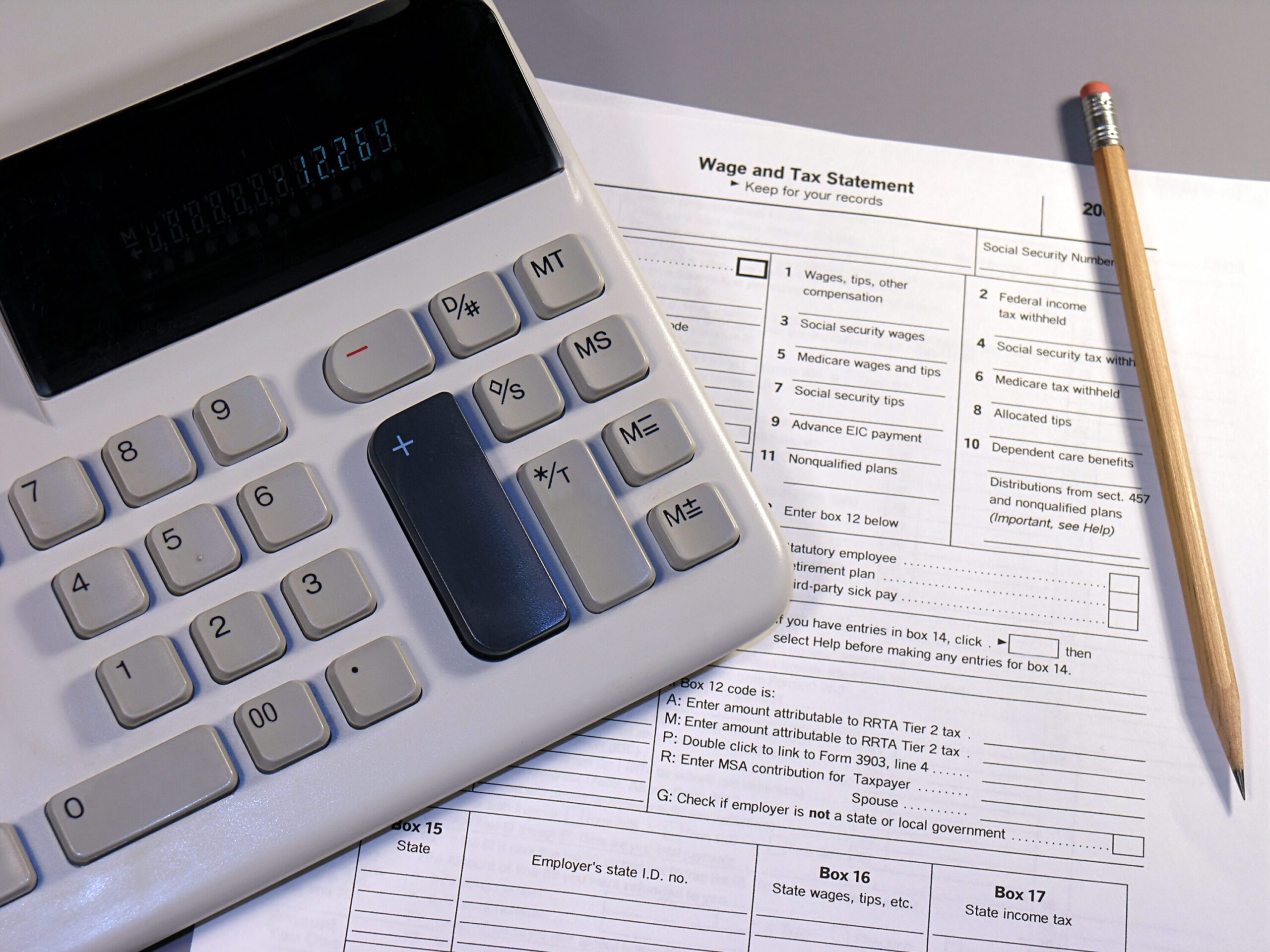 Homme calculant la conversion d'un salaire brut en net sur une calculatrice